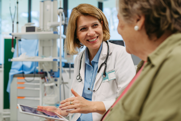 Geriatrician talking about test results with senior patient during check-up. Medical consultation.