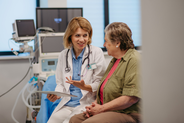 Geriatrician talking with senior patient during check-up. Medical consultation.