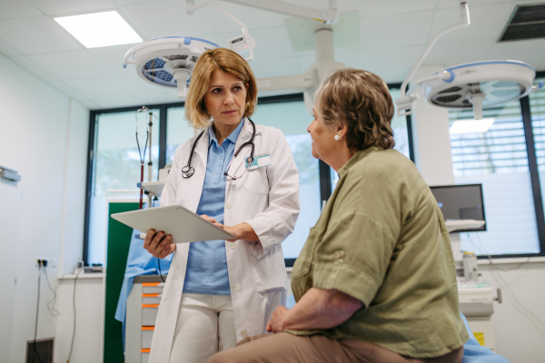 Geriatrician talking about test results with senior patient during check-up. Medical consultation.