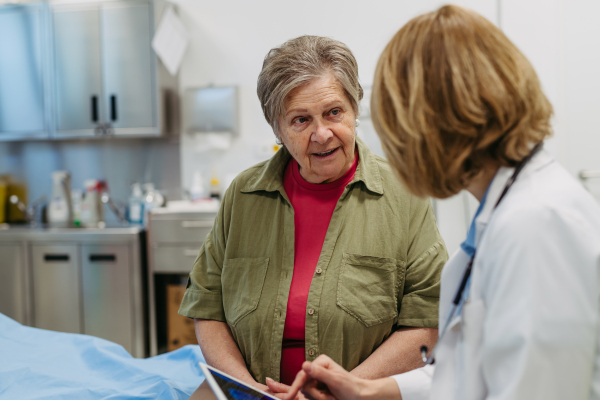 Geriatrician talking about test results with senior patient during check-up. Medical consultation.