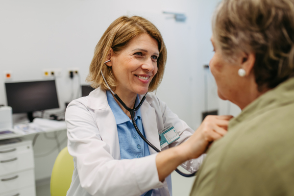 Geriatrician listening to senior patient's heartbeat. Routine health exam for elderly woman.