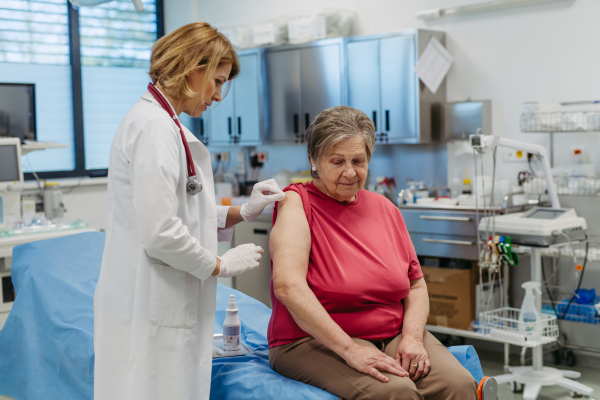 Elderly patient being vaccinated by doctor. Preventive care.