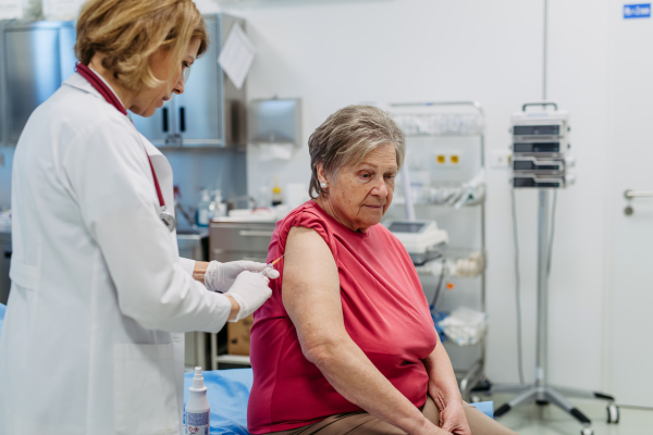 Elderly patient being vaccinated by doctor. Preventive care.