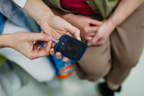 Top view of nurse preparing glucose meter for blood sugar test
