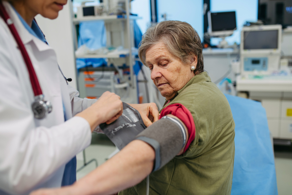 Senior woman having blood pressure checked during preventive medical exam