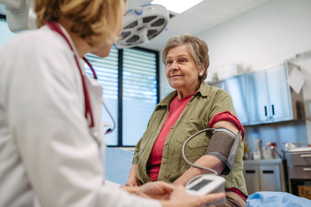 Senior woman having blood pressure checked during preventive medical exam