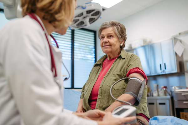 Senior woman having blood pressure checked during preventive medical exam