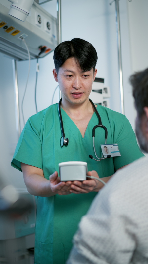Male doctor measuring blood pressure of overweight patient.