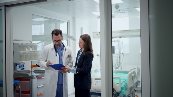 Pharmaceutical sales respresentative introducing herself to doctor, hospital setting.