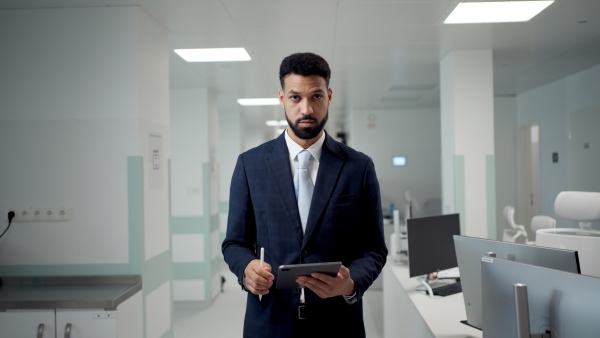 Medical sales respresentative working on tablet. Hospital director, manager in modern medical clinic.