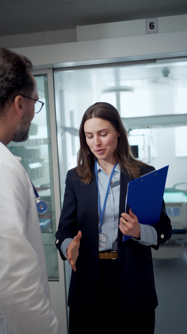 Pharmaceutical sales respresentative introducing herself to doctor, hospital setting.