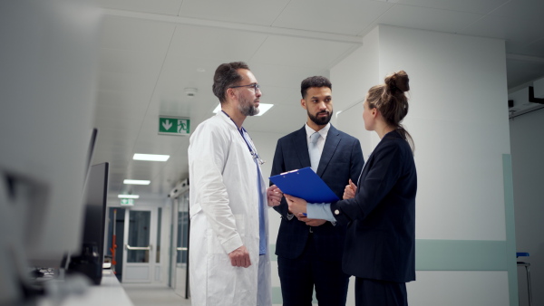 A pharmaceutical sales respresentatives showing doctor new medications. Group presentation in hospital setting.