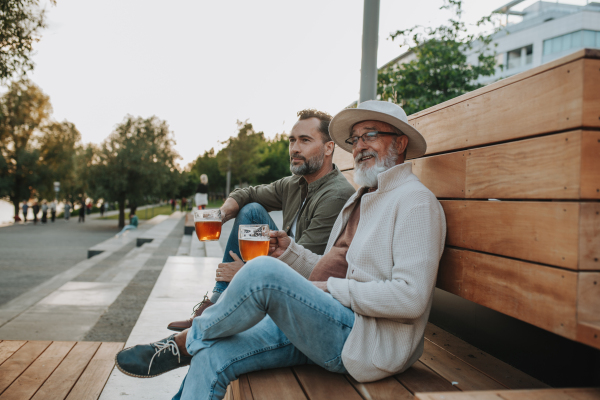 Happy father and son sharing drinks on a sunny day. Fathers day concept.