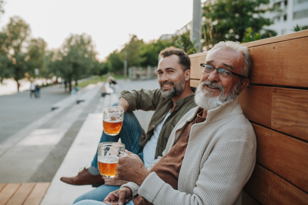 Happy father and son sharing drinks on a sunny day. Fathers day concept.