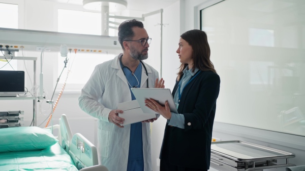 Pharmaceutical sales respresentative with doctor, hospital setting.