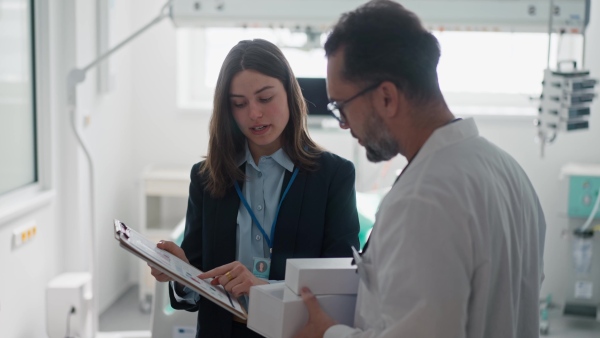 Pharmaceutical sales respresentative with doctor, hospital setting.