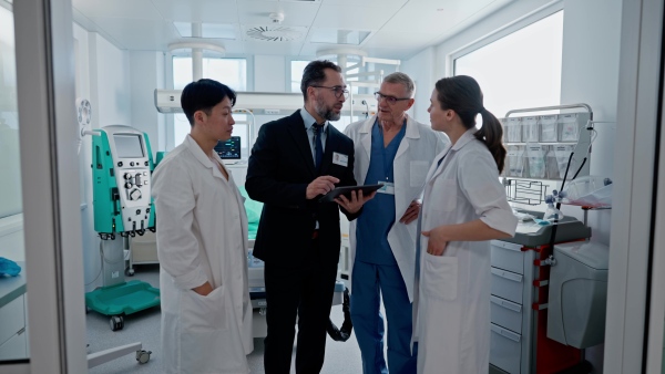 A pharmaceutical sales respresentative showing doctor new medications. Group presentation in hospital setting.