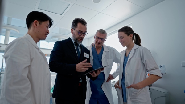 A pharmaceutical sales respresentative showing doctor new medications. Group presentation in hospital setting.