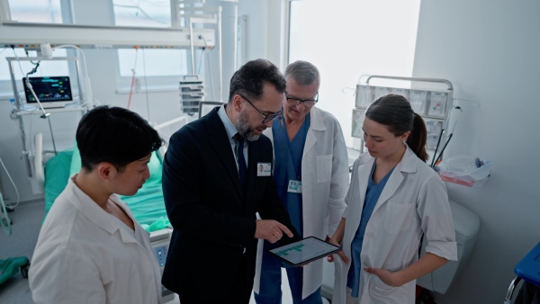 A pharmaceutical sales respresentative showing doctor new medications. Group presentation in hospital setting.