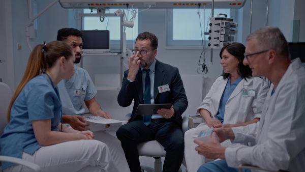 A pharmaceutical sales respresentative showing medical satff new medications. Group presentation in hospital setting.