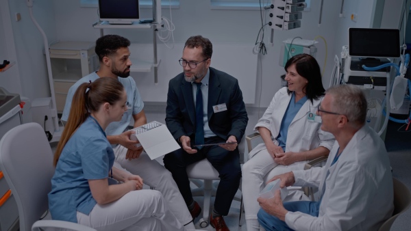 A pharmaceutical sales respresentative showing medical satff new medications. Group presentation in hospital setting.