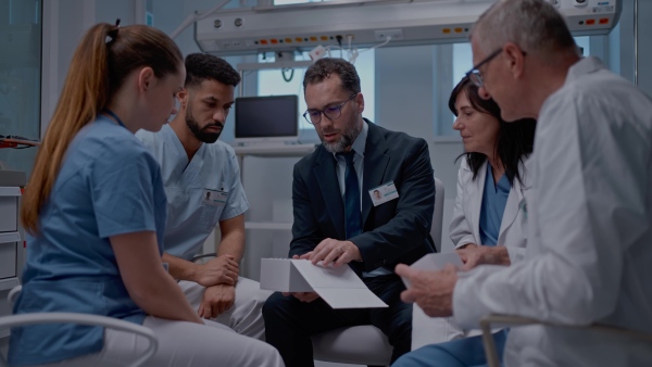 A pharmaceutical sales respresentative showing medical satff new medications. Group presentation in hospital setting.