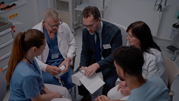 A pharmaceutical sales respresentative showing medical satff new medications. Group presentation in hospital setting.