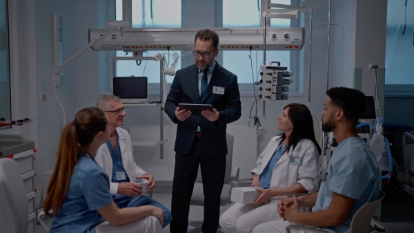 A pharmaceutical sales respresentative showing medical satff new medications. Group presentation in hospital setting.