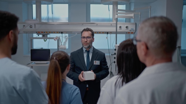 A pharmaceutical sales respresentative showing medical satff new medications. Group presentation in hospital setting.