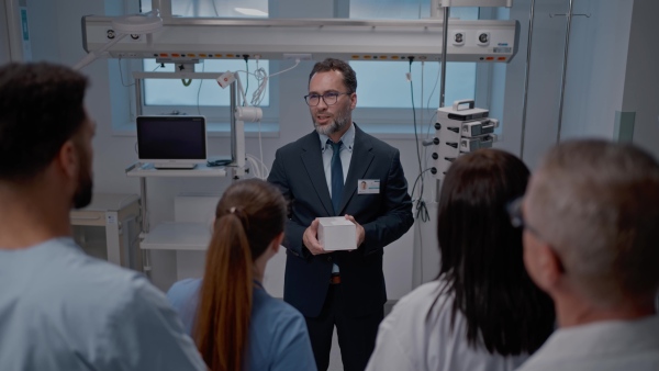 A pharmaceutical sales respresentative showing medical satff new medications. Group presentation in hospital setting.