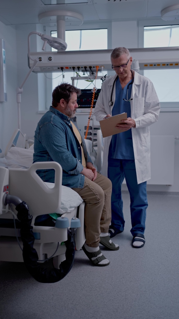 A doctor explaining the risks of leaving the hospital early as the patient prepares to sign an AMA form.