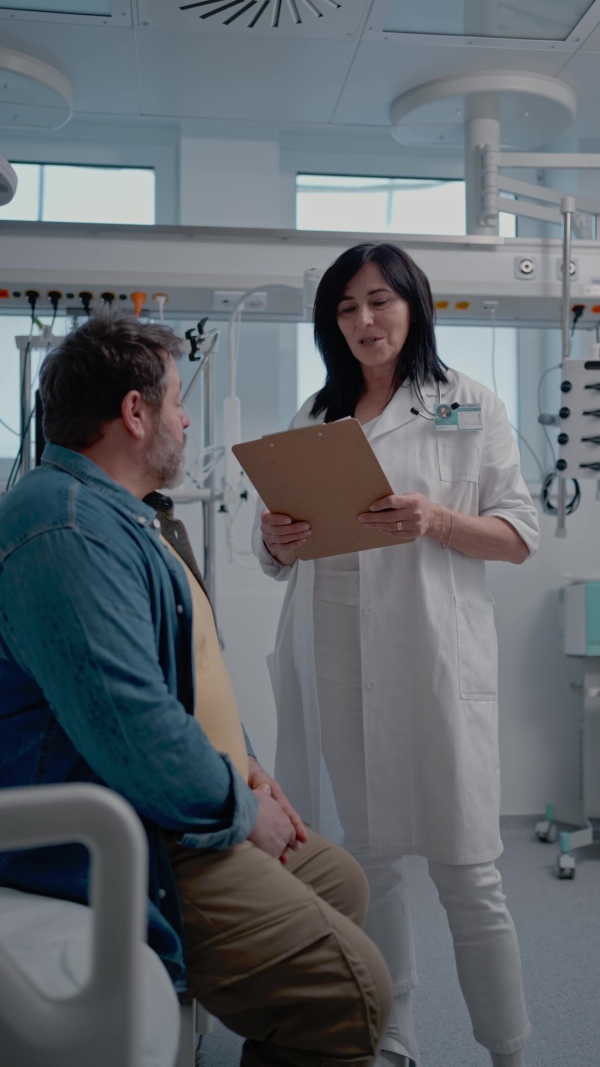 A doctor explaining the risks of leaving the hospital early as the patient prepares to sign an AMA form.