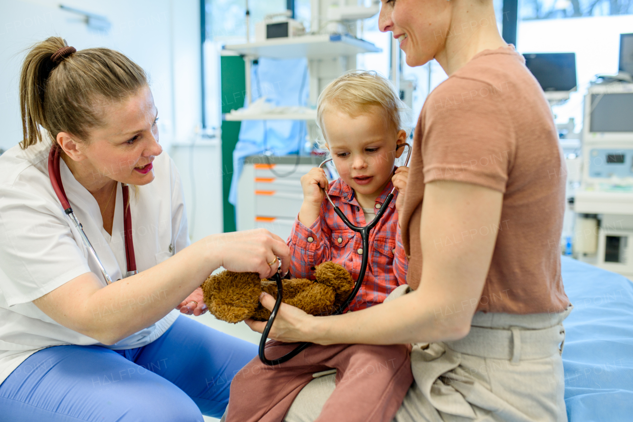 Little boy trying pediatrician's stethoscope during medical examination in doctor's office.