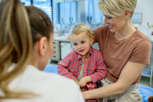 Female pediatrician examing little boy during preventive health check up.