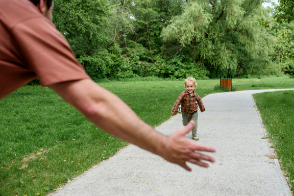 Happy little boy running to his waiting father.