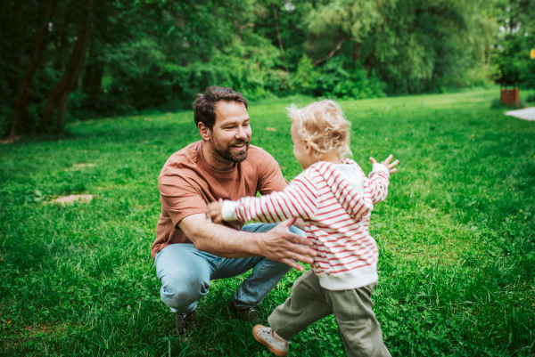 Happy little boy running to his waiting father.