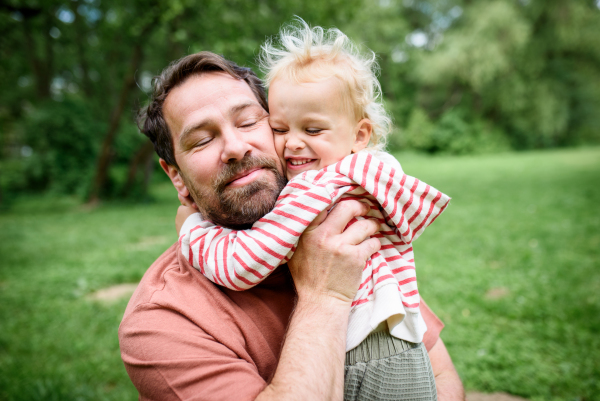 Portrait of dad hugging little son, enjoying time together. Fathers day concept.