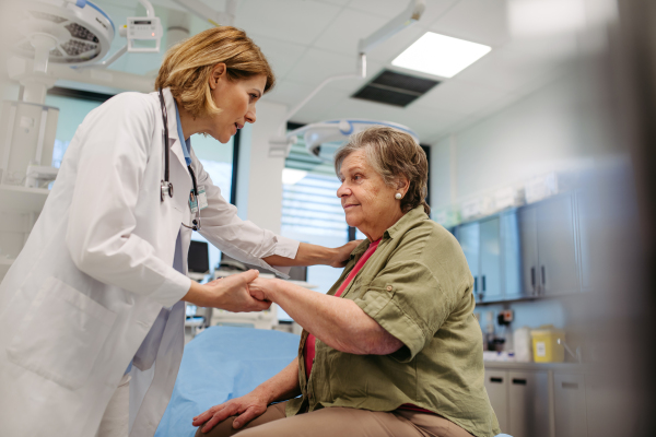 Kind physician comforting elderly patient with gentle hand touch, offering reassurance.