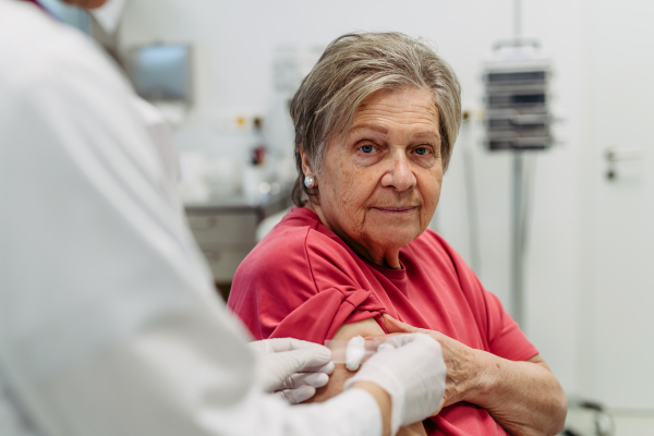 Close up of arm of elderly patient after vaccination. Preventive care.
