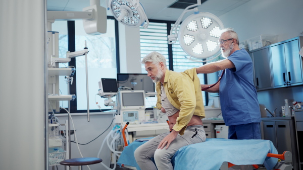 Doctor examining sick patient, listening to breathing with stethoscope.
