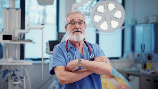 Video of older doctor standing in examination room in hospital. Banner with copy space.
