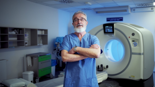 Video of older doctor standing in examination room in hospital. Banner with copy space.