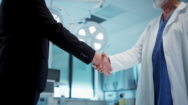 Hospital business handshake in medical environment. Strategic collaboration in medical industry.