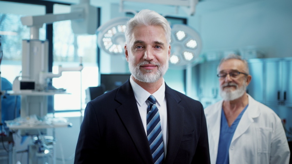 Video of pharmaceutical sales representative with doctor standing behind him. Hospital director, manager of private medical clinic.