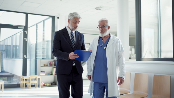 Doctor talking with pharmaceutical representative, hospital setting.
