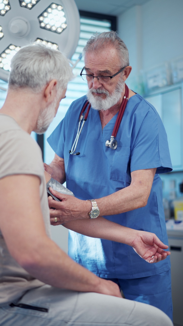 Doctor taking patient's blood pressure using a digital blood pressure monitor.