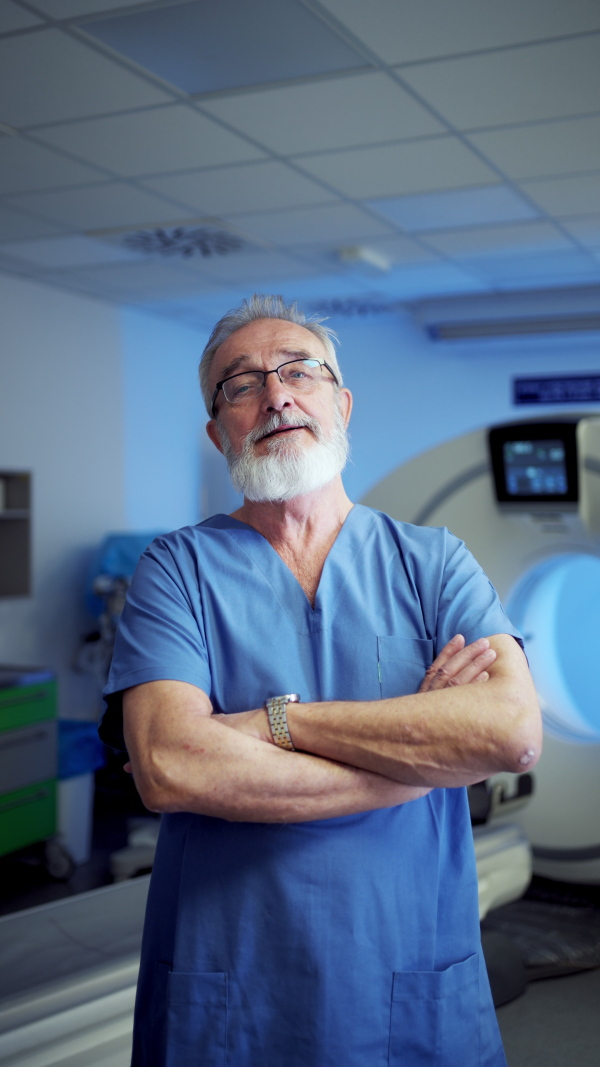 Video of older doctor standing in examination room in hospital. Banner with copy space.