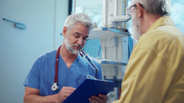 Patient sitting on examination table, talking with doctor about symptoms and his health problems.