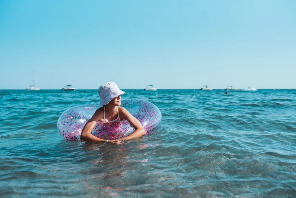 Girl on beach with swim ring. Summer beach holiday.
